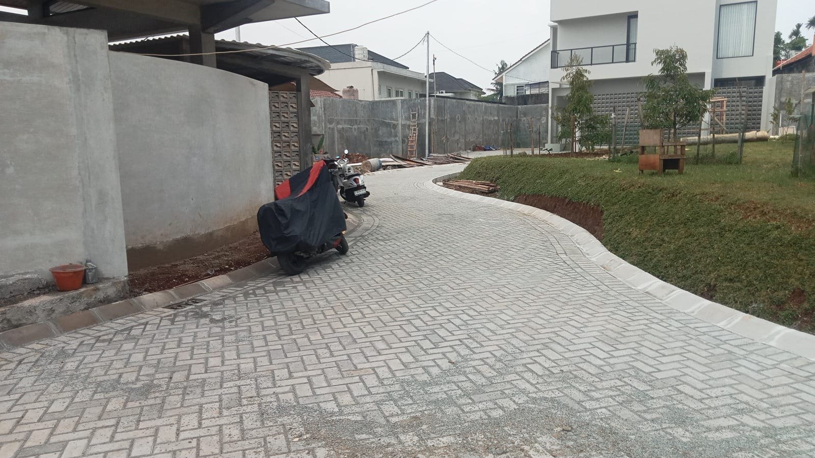 Jalan lingkungan hunian dengan paving abu-abu